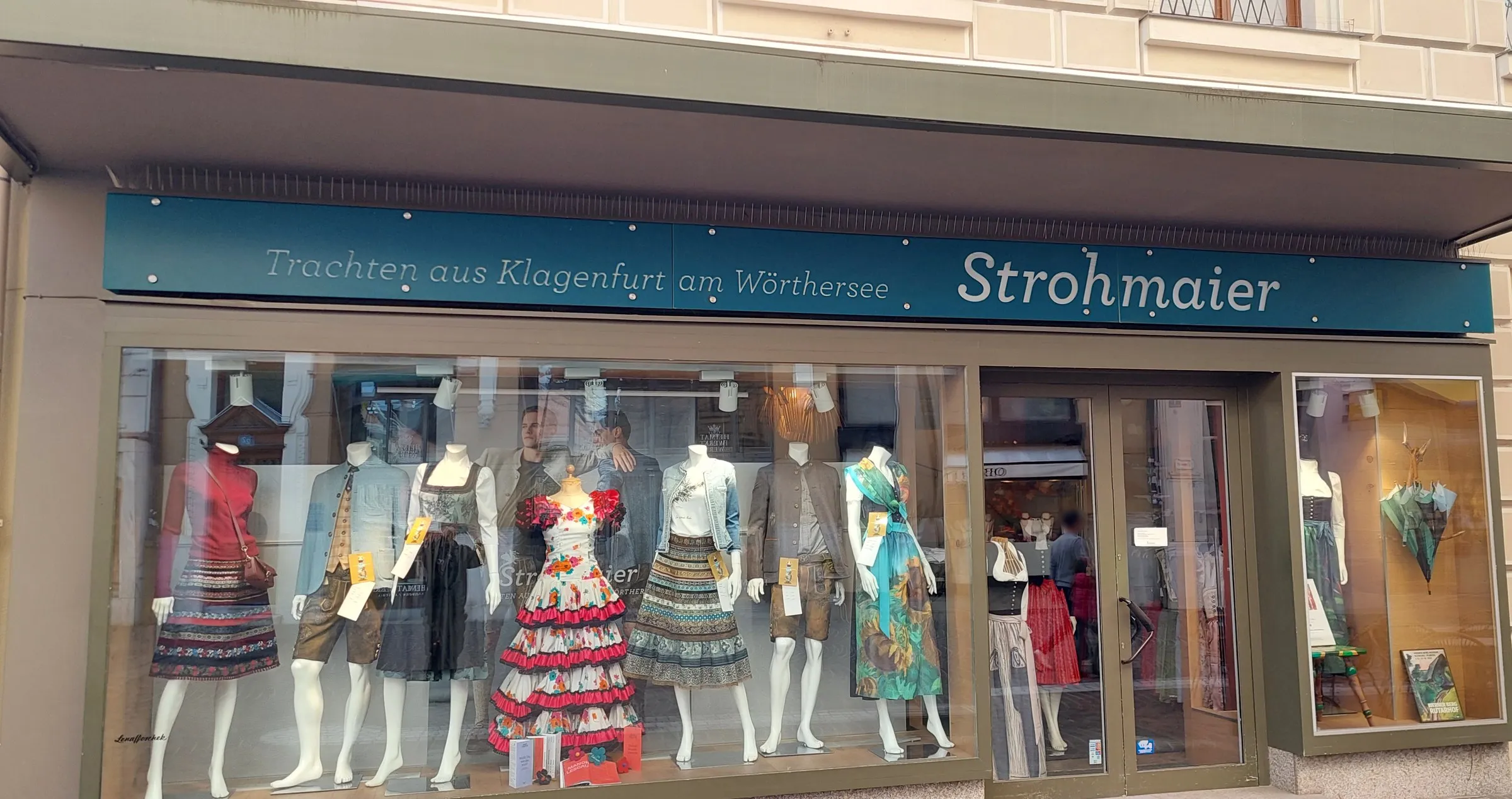 Ladenfront von Strohmaier: der lange Leuchtkasten über dem Schaufenster, bei Tag