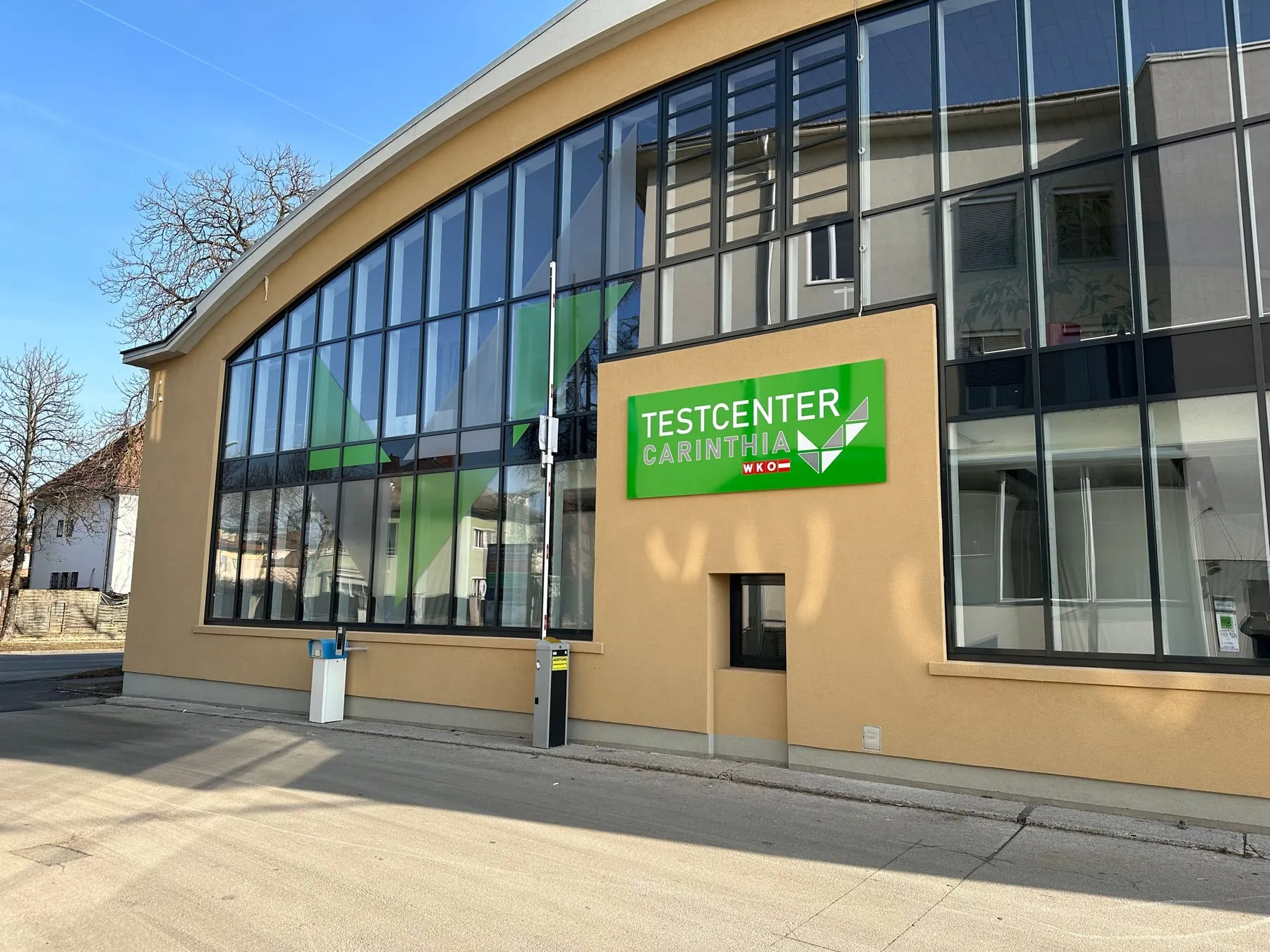 Schild an der Fassade mit Bogen-Glasfront