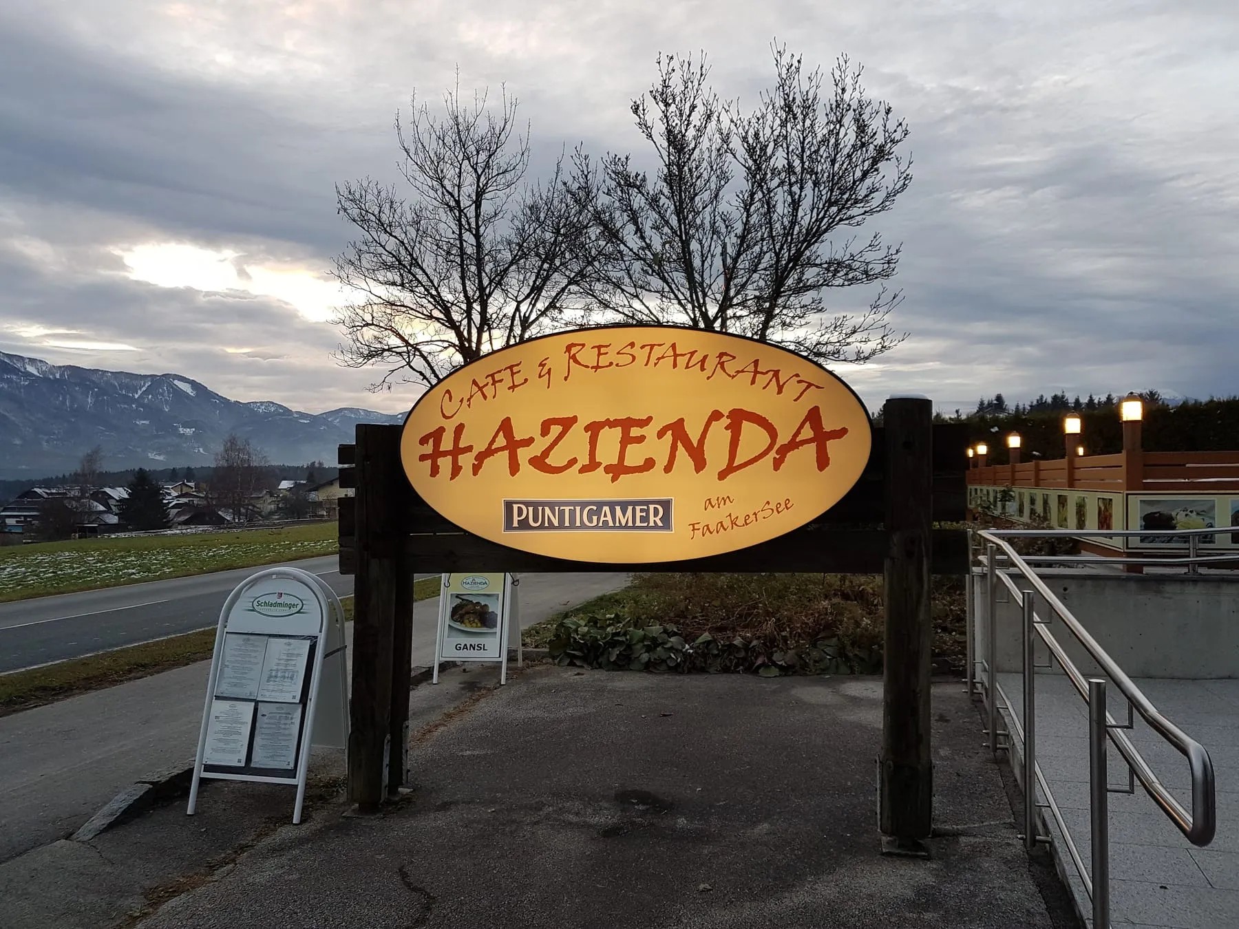 Beleuchtetes Schild eines Cafés und Restaurants mit Puntigamer-Logo in der Dämmerung