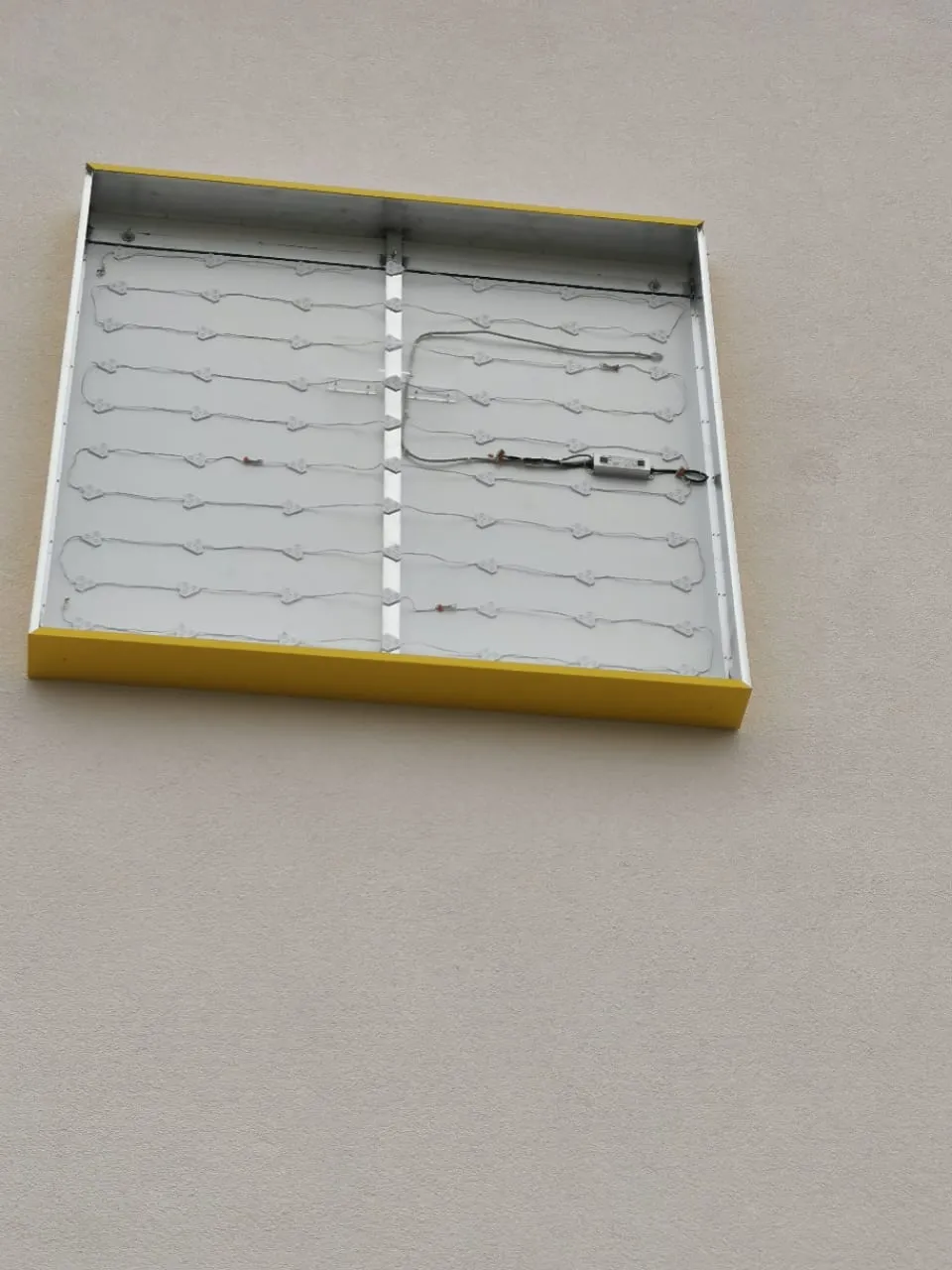 Leuchtkasten an der Fassade bei der Montage, die Frontplatte fehlt noch