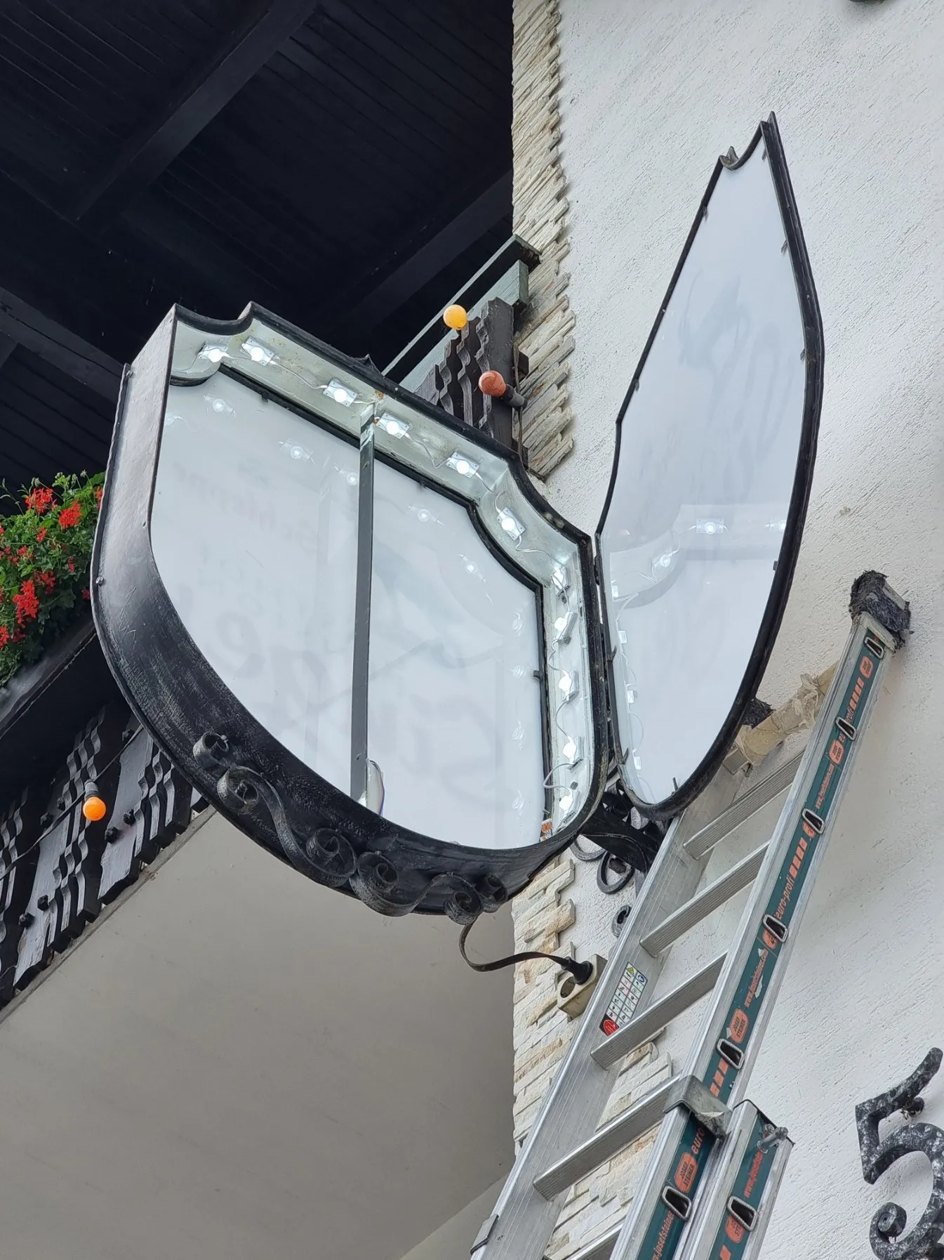 Wappenförmiger Ausleger des Gasthofs Singer, aufgeklappt: neue LED-Module rundum am Rand
