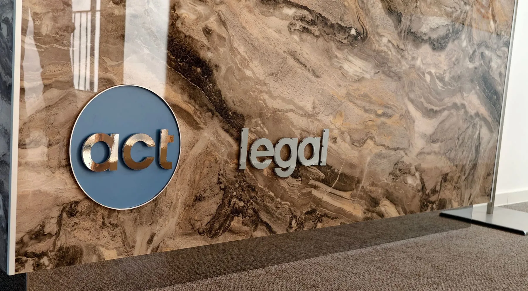 Empfangstheke in Marmoroptik mit plastischem Logo von act legal