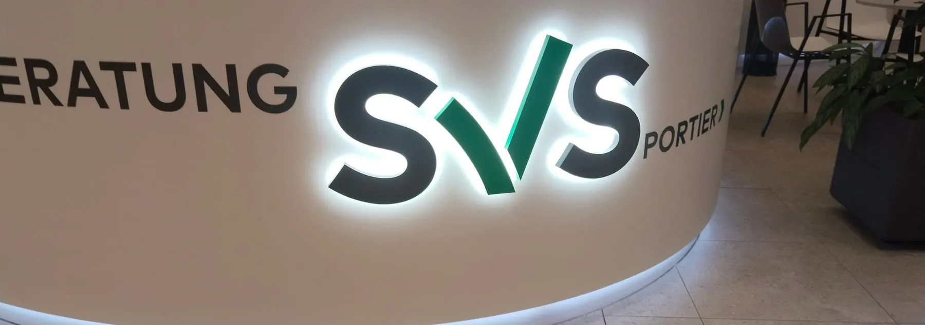 Empfangstheke der SVS mit hinterleuchtetem 3D-Logo