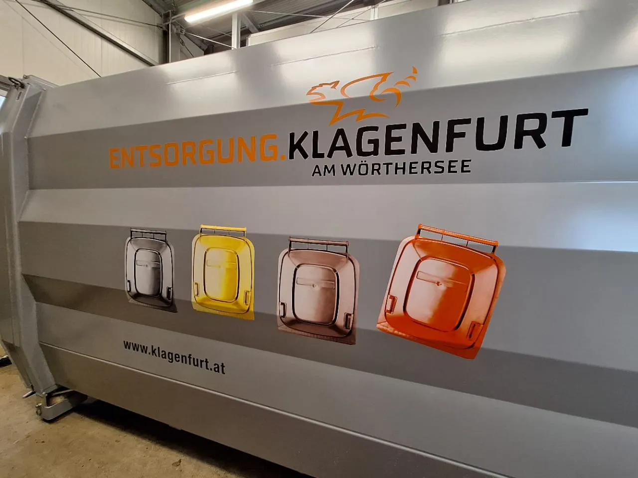 Presscontainer der Entsorgung Klagenfurt, foliert mit Stadtlogo und gedruckten Mülltonnen